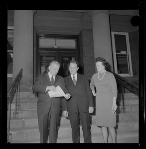 Woman and two men on the steps of the courthouse