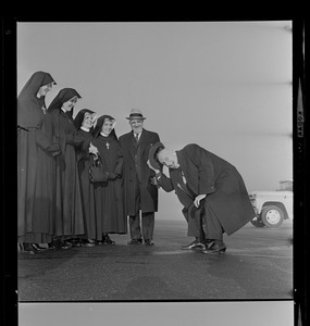 Jimmy Durante, the Schnozzola, in typical gesture, bows, tipping hat to Columbian Sisters, who met him at airport before his appearance last night at Columbian benefit at Garden