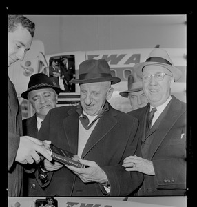Jimmy Durante, middle, holding a copy of A Topographical History, while standing with Middlesex Sheriff Howard W. Fitzpatrick, right