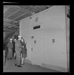 Crew member showing a woman the NASA Naval Aerospace Medical Institute door