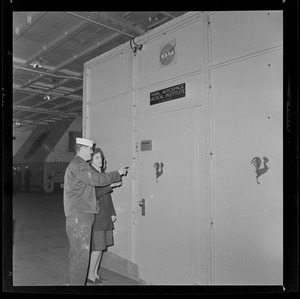 Crew member showing a woman the NASA Naval Aerospace Medical Institute door