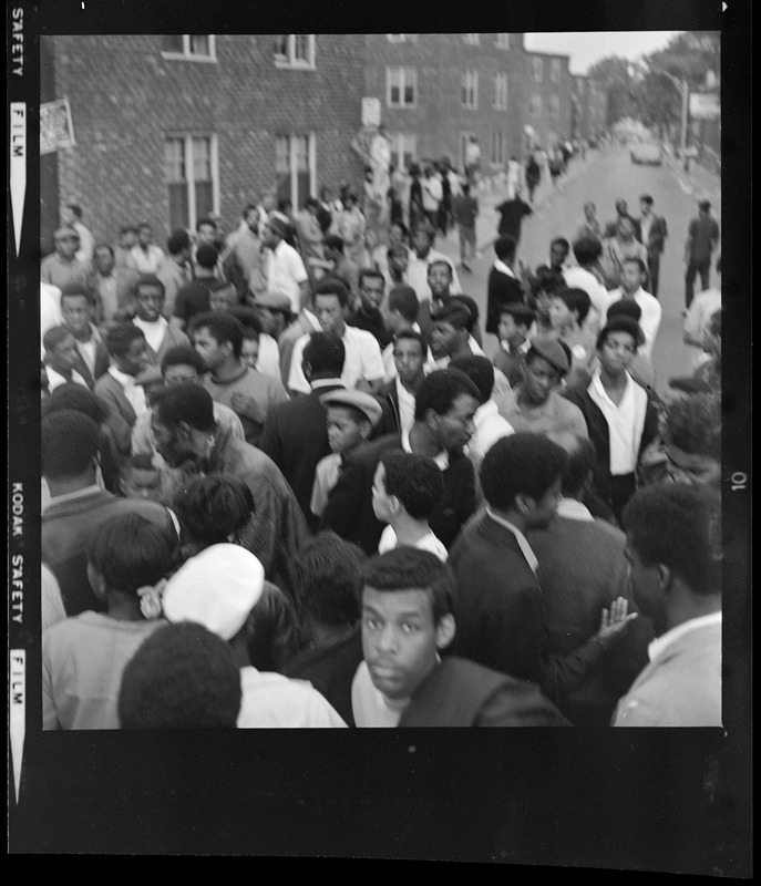 Group of people gathered in the street, looking at a building - Digital ...