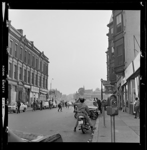 Street scene with a police officer on a motorcycle and students running