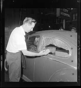 James Devereaux of Franklin holds a brick that was hurled by one of a gang of youths who surrounded his car and began smashing his windows at the corner of Harrison Ave. and Dudley St. in Roxbury