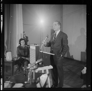 Kevin White addressing the room during the debate as Louise Day Hicks looks on
