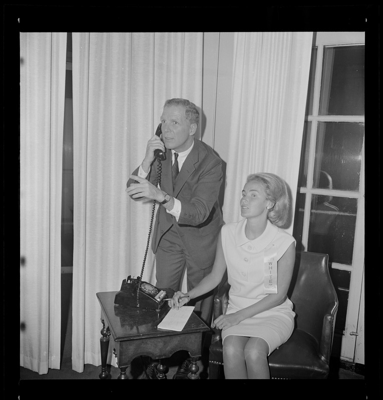 Kevin White gets late returns by telephone at his campaign headquarters last night, with his wife standing by to tabulate them