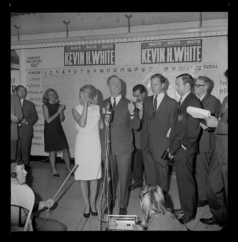 Sec. of State and Mrs. Kevin White wave happily to campaign workers at his headquarters last night