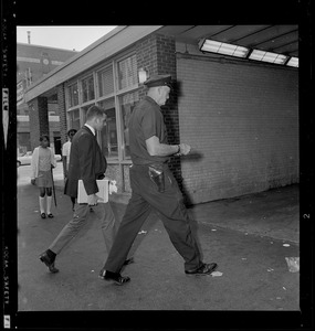 Man walking with a police officer into a hospital