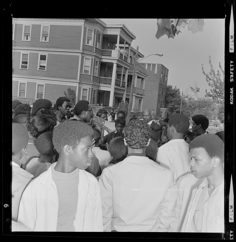 Students in street gathered around to listen John A. Joyce, Acting Principal of Martin Luther King Jr. school