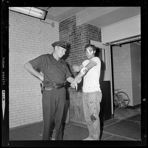 Construction worker Kenneth Kurker after sustaining injuries from a gang of 30 youths, with a police officer