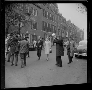 Kevin White and his wife Kathryn walking in the street and surrounded by cameramen