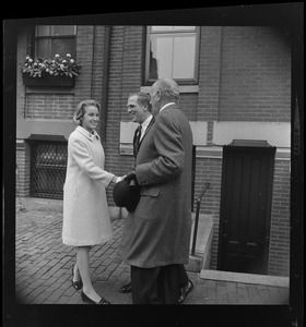 Kathryn White shaking hands with another man as her husband looks on