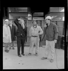 Kevin White wearing a construction hat, looks up