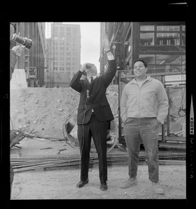 Kevin White points up as another man looks on while at a construction site