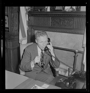 Secretary of State Kevin H. White sitting at desk and speaking on the phone