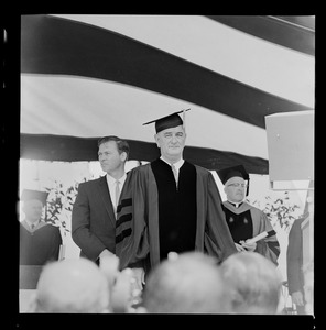 President Lyndon B. Johnson in cap and gown on stage at Holy Cross commencement