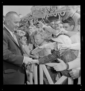 President Johnson shaking hands with a young boy on arrival at Worcester Airport