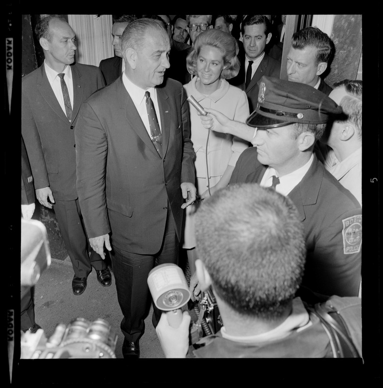 President Johnson talks with a reporter while walking out of N.E. Baptist Hospital, with Joan Kennedy at his side