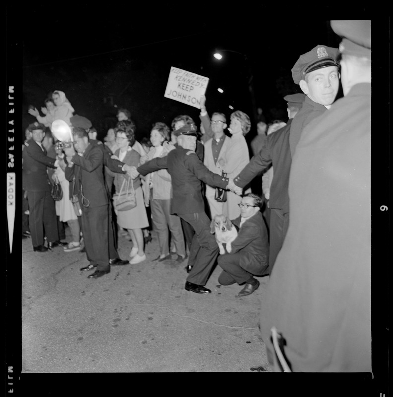 Police form a barricade in front of a crowd