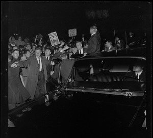 President Johnson waves to supporters while standing by a vehicle