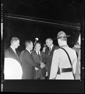 President Johnson shakes hands with Massachusetts State Treasurer Robert Crane while others look on