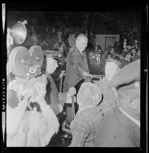 President Johnson shakes a supporter's hand while making his way through the crowd