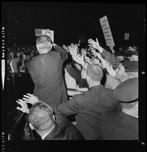 President Johnson entering a vehicle and waving to supporters