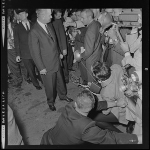 President Johnson standing by photographers and reporters