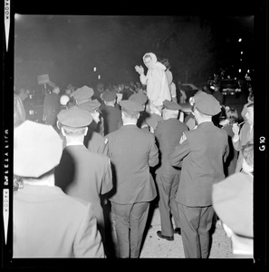 A woman is seen waving above a crowd