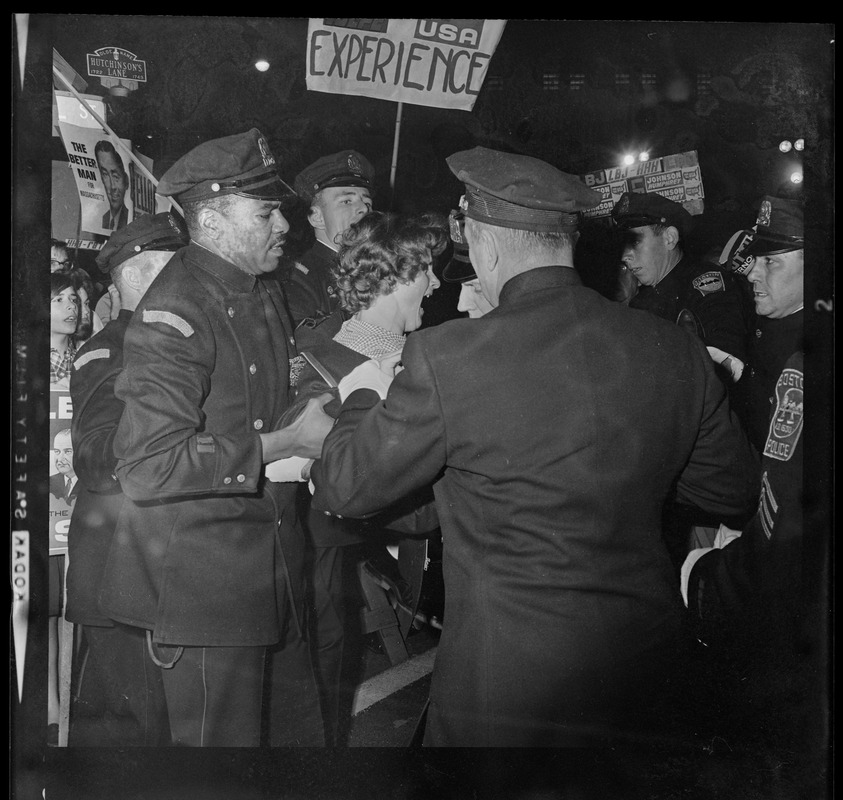 Police escorting a woman back across the line