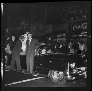 President Johnson sits on top of car during procession