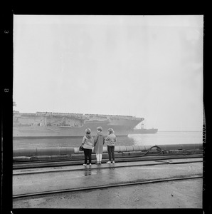 Three women watch as USS Wasp leaves Boston Harbor