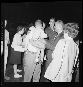 Lt. Gov. Bellotti taking a child from a man's arms