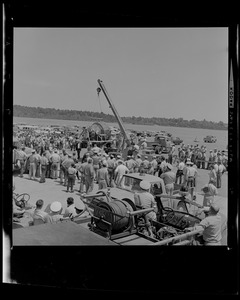 Crowd looks on as crane is used upon Gemini 9's arrival to Weymouth Naval Air Station