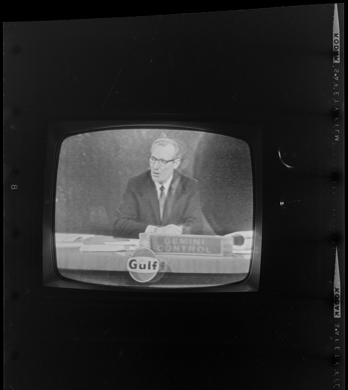 Newscaster seen on television reporting from Gemini Control