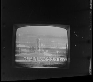 Scene of Gemini 6 on television screen and with caption "Gemini 6 Scrubbed"
