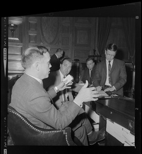 Representative H. Thomas Colo, foreground, and three other men, seated and in mid-discussion