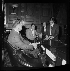 Representative H. Thomas Colo, foreground, and three other men, seated and in mid-discussion