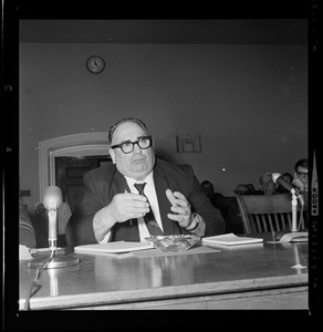 Man with glasses on, seated and addressing the committee
