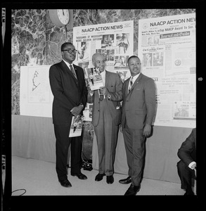 Roy Wilkins with two others holding materials from the NAACP Convention