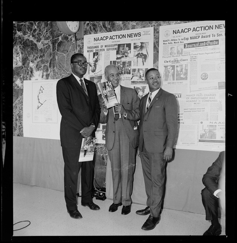 Roy Wilkins with two others holding materials from the NAACP Convention