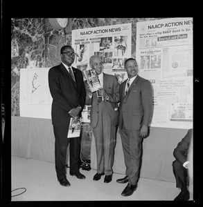 Roy Wilkins with two others holding materials from the NAACP Convention