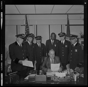 Police Commissioner Edmund McNamara reads directive to his new superintendent-in-chief and deputy superintendents during the first meeting at which the whole group has been present