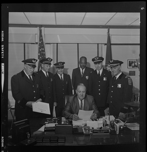 Police Commissioner Edmund McNamara reads directive to his new superintendent-in-chief and deputy superintendents during the first meeting at which the whole group has been present