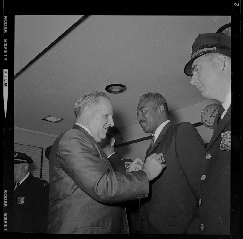 Police Commissioner Edmund McNamara pinning a badge on Dept. Supt. Herbert A. Craigwell