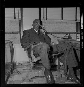 Dep. Supt. Herbert A. Craigwell seated at a desk and talking on the phone