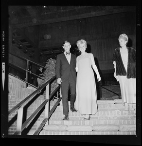 Woman in floor-length dress and man walking down brick stairs at the opening of Boston City Hall