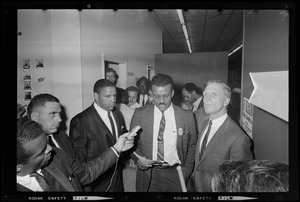 A man speaking while Mayor White, far right, and another man, far left, look on
