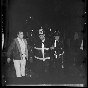 Firefighter officials walking with another man