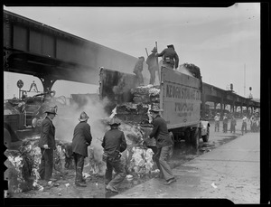 Firefighters hosing down bundled material from a Keogh Storage Trucking Co. truck